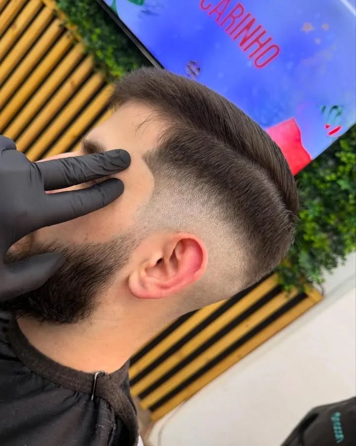 Degradê alto com o topo penteado para trás, visto de lado.